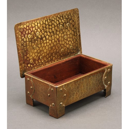 3365 - An Arts and Crafts brass rectangular cigar box, riveted strap hinges and bracket feet, planished ove... 