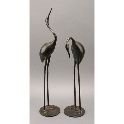 3399 - Modern School, a pair of verdigris patinated bronzes, of cranes, circular bases, 53.5cm and 40cm hig... 