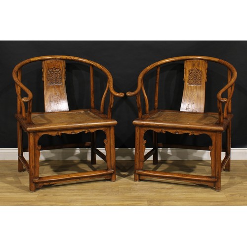 3350 - A pair of large Chinese elm horseshoe chairs, each splat carved with stylised chilóng and organic me... 