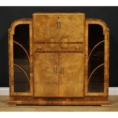 3328 - An Art Deco walnut drinks or cocktail cabinet, fall front above a central door and two doors flanked... 