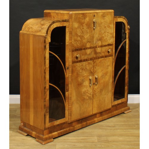 3328 - An Art Deco walnut drinks or cocktail cabinet, fall front above a central door and two doors flanked... 