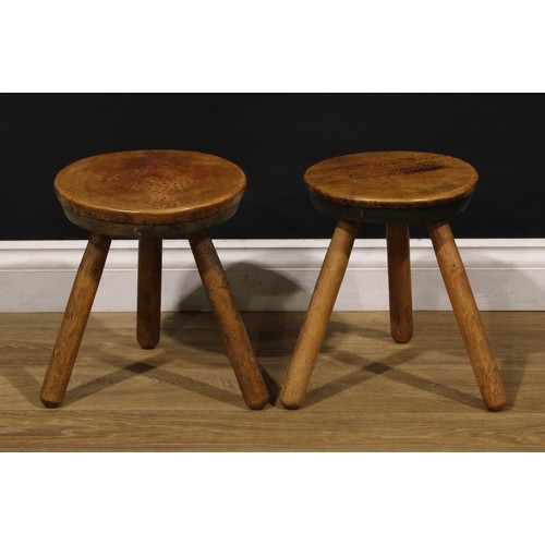 3347 - A pair of Art Deco design ash and elm tripod stools, probably Welsh, each top covered in tooled leat... 