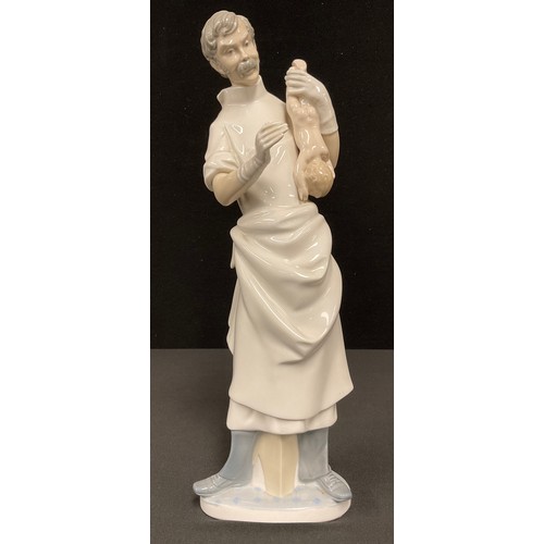 245 - Ceramics - a Lladro figure, Obstetrician or Doctor with Baby, now retired, 36cm high overall