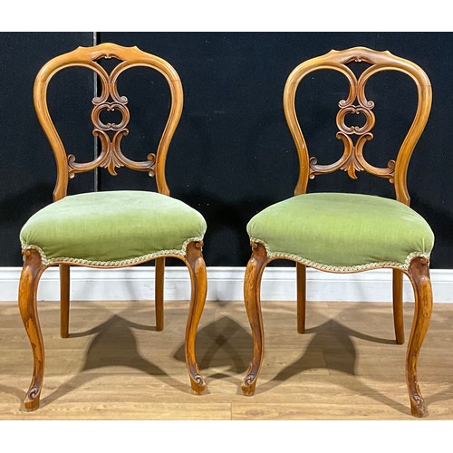 426 - A pair of Victorian walnut side or boudoir chairs, each back carved with C-scrolls, stuffed-over sea... 