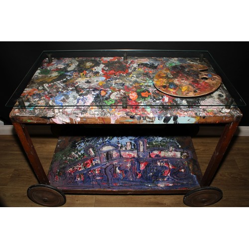 3343 - A mid-20th century artist’s studio table, glazed rectangular top enclosing an accumulation of discar... 