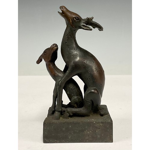 493 - A Chinese patinated bronze desk seal, in the form of an interlocking deer and faun, 11.5cm high