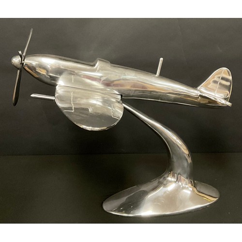 494 - A large polished metal desktop model, as a Spitfire, 60cm long, 50cm wide, 30cm high