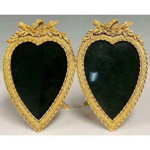 496 - A reproduction Louis XVI style gilt brass double love heart shaped photograph frame, the crests carv... 