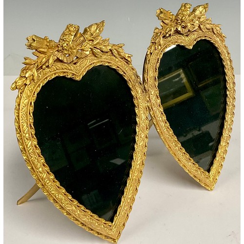 496 - A reproduction Louis XVI style gilt brass double love heart shaped photograph frame, the crests carv... 