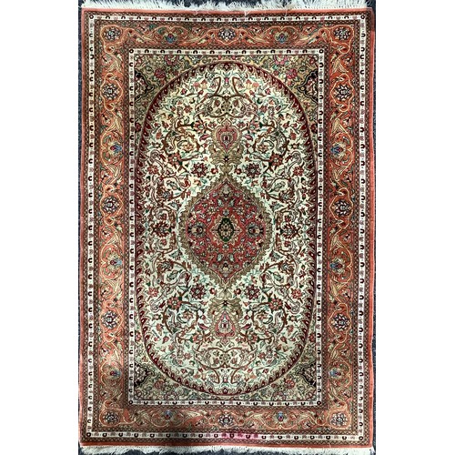 507 - A Middle Eastern rectangular rug or carpet, the field worked with foliate scrolls, in tones of red, ... 