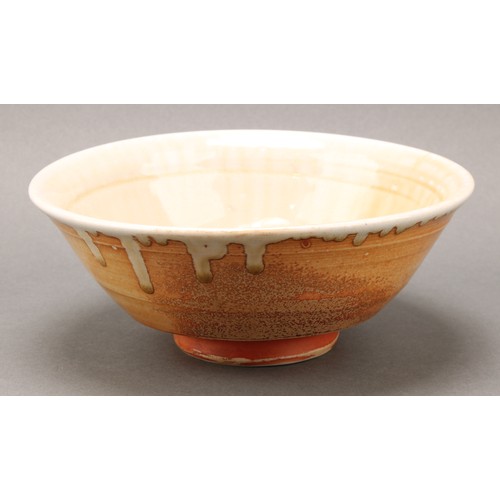 2468 - A Phil Rogers studio pottery bowl, glazed in tones of green and celadon on an orange ground, 20cm di... 