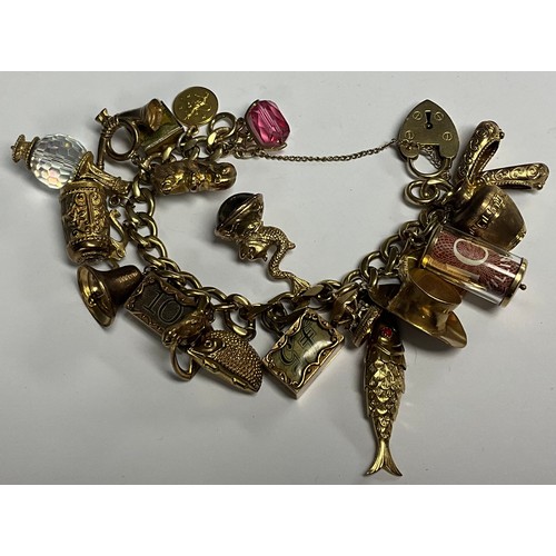 5151 - A 9ct gold charm bracelet, set with 20 charms and a half sovereign, 1902, 93.09g gross