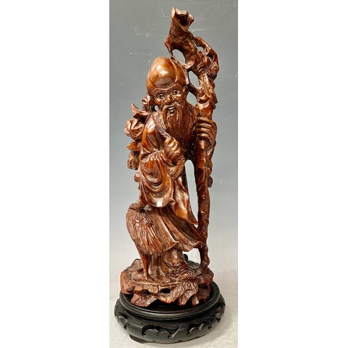 933 - A Japanese root carving, wise elder with crane at his feet, 30cm, hardwood base, c.1900