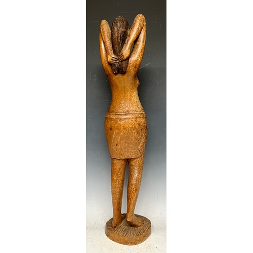 69 - Tribal Art - a North African carved wooden figure, of a woman parting her hair, circular base, 66cm ... 