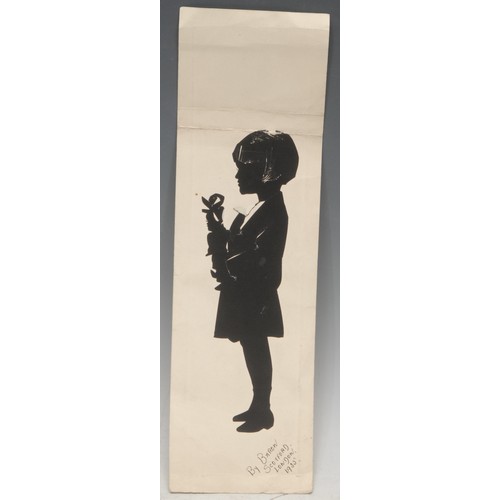 261 - A George V cut-out full length silhouette, of a young girl holding a doll, facing to dexter, signed ... 