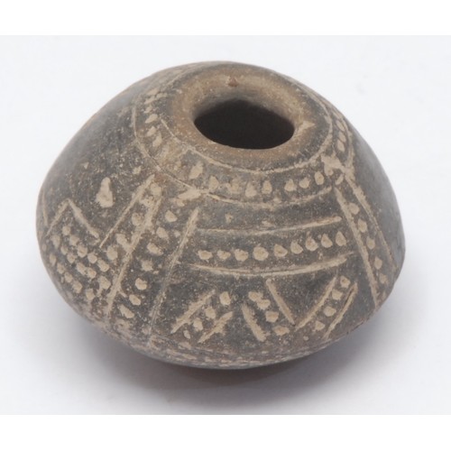 186 - Antiquities - a South American spindle whorl burial object, carved with geometric patterns in the Ma... 