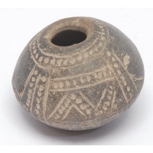 186 - Antiquities - a South American spindle whorl burial object, carved with geometric patterns in the Ma... 