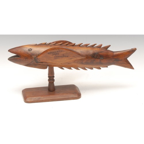 1029 - Treen - a Pitcairn Island wooden souvenir, carved as a flying fish, mounted on turned stand, stamped... 