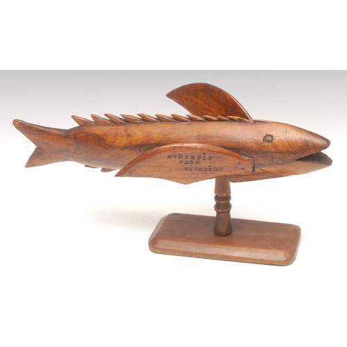 1029 - Treen - a Pitcairn Island wooden souvenir, carved as a flying fish, mounted on turned stand, stamped... 