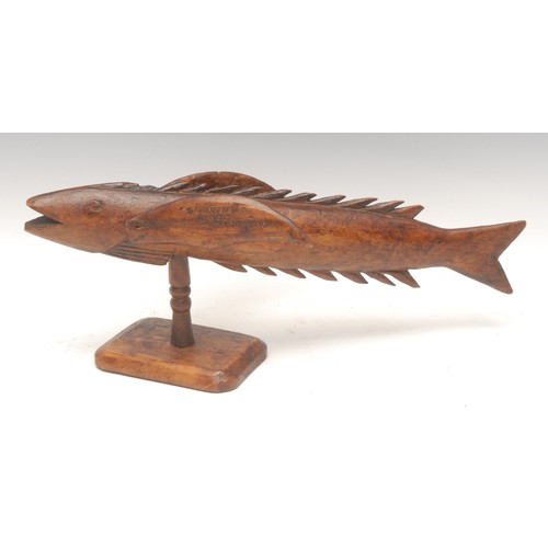 1028 - Treen - a Pitcairn Island wooden souvenir, carved as a flying fish, mounted on turned stand, stamped... 