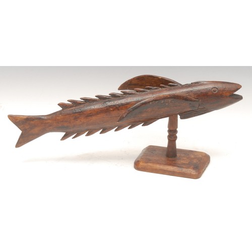 1028 - Treen - a Pitcairn Island wooden souvenir, carved as a flying fish, mounted on turned stand, stamped... 