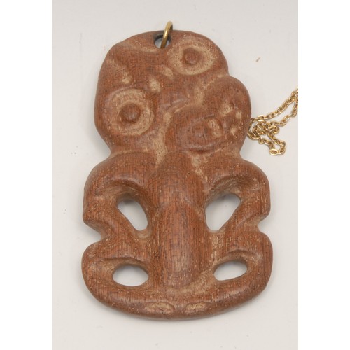 58 - Tribal Art - a Maori hardwood tiki pendant, typically carved and pierced, 9cm long, New Zealand, fir... 