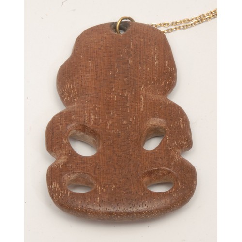 58 - Tribal Art - a Maori hardwood tiki pendant, typically carved and pierced, 9cm long, New Zealand, fir... 