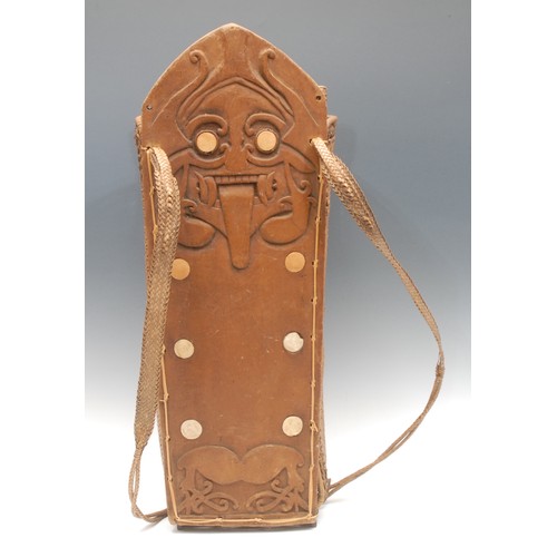 16 - Tribal Art - a carry basket, the central plank carved with a grotesque mask and inlaid with bone rou... 