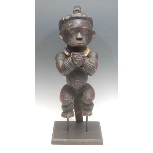 28 - Tribal Art - a Fang Byeri figure, Ntumu, depicted crouched, holding a vessel, adorned with beadwork ... 