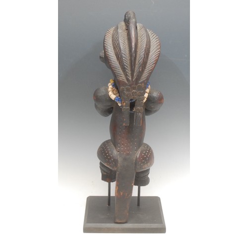 28 - Tribal Art - a Fang Byeri figure, Ntumu, depicted crouched, holding a vessel, adorned with beadwork ... 