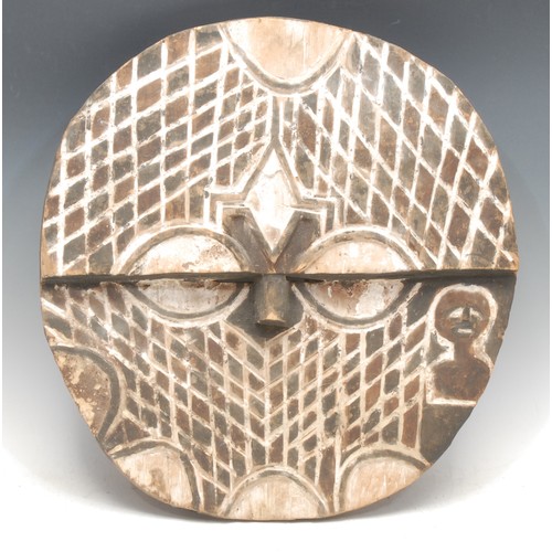 82 - Tribal Art - a Teke moon shaped mask, typically carved with abstract geometric motifs, 41cm diam, De... 