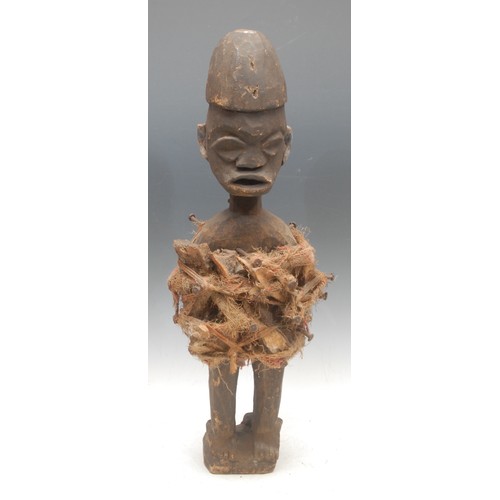 91 - Tribal Art - a Yombe fetish figure, adorned with iron nails, bone fragments and fibres, 60cm high, D... 