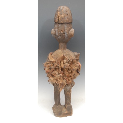 91 - Tribal Art - a Yombe fetish figure, adorned with iron nails, bone fragments and fibres, 60cm high, D... 