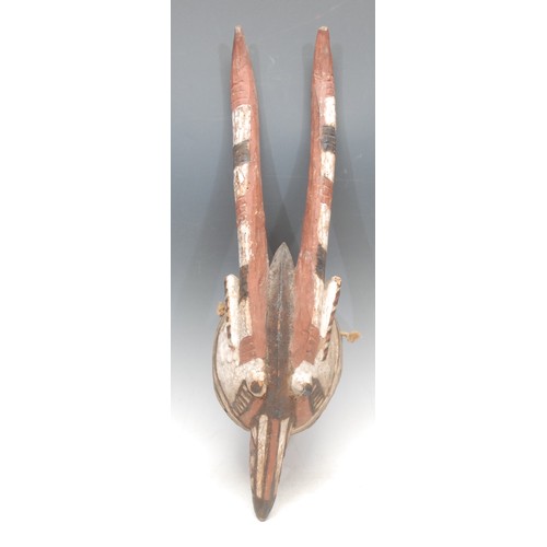 62 - Tribal Art - a Mossi antelope mask, decorated with abstract motifs in kaolin, and red and brown eart... 