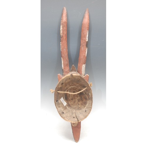 62 - Tribal Art - a Mossi antelope mask, decorated with abstract motifs in kaolin, and red and brown eart... 