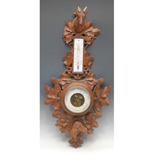 1025 - Treen - a 19th century Black Forest barometer, carved with heads of a dog and a dear, glass eyes, oa... 