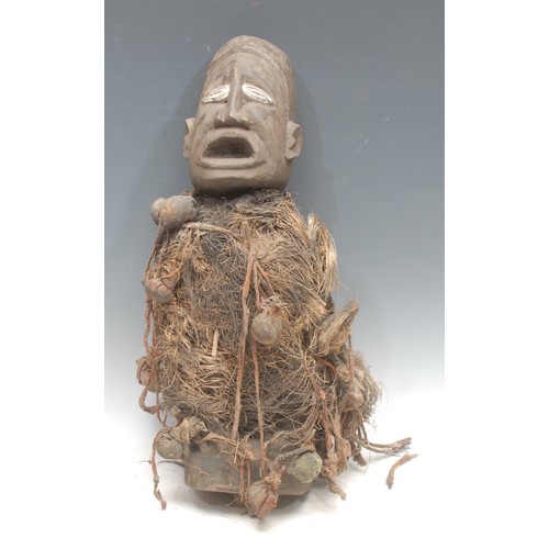 36 - Tribal Art - a Kongo nkisi power figure, white painted eyes, adorned with fibres and cloth-wrapped p... 