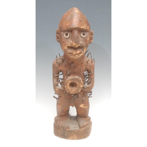 35 - Tribal Art - a Kongo nkisi power figure, typically adorned with iron nails, painted eyes adorned wit... 