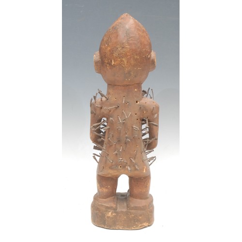 35 - Tribal Art - a Kongo nkisi power figure, typically adorned with iron nails, painted eyes adorned wit... 