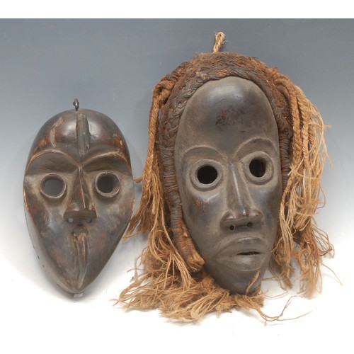 21 - Tribal Art - a Dan mask, of typical heart shaped concave form, projecting cylindrical eyes, 23cm lon... 