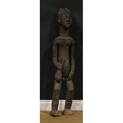 45 - Tribal Art - a large Bangwa/Bamileke figure, he stands, holding an implement, 122cm high, Cameroon