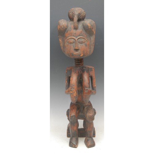 54 - Tribal Art - a Luba female figure, elaborate coiffure, seated on a stool , traces of red pigment to ... 