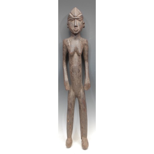 76 - Tribal Art - a Senufo figure, of elongated proportions, stylised features, geometric scarification, ... 