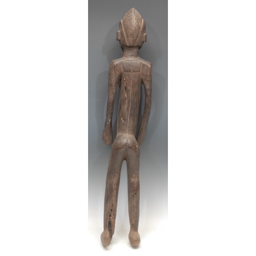 76 - Tribal Art - a Senufo figure, of elongated proportions, stylised features, geometric scarification, ... 