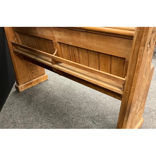 36 - A 19th century pitch pine church pew, carved with a rose to each end, bible shelf to back, 97cm high... 