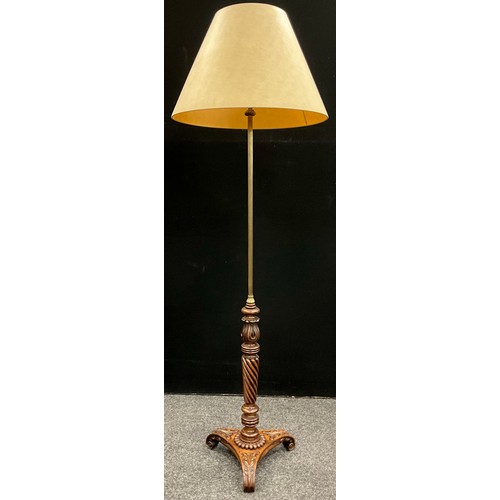 39 - A carved walnut and brass standard lamp, the shade supported by a reeded brass pole, upon a lower co... 