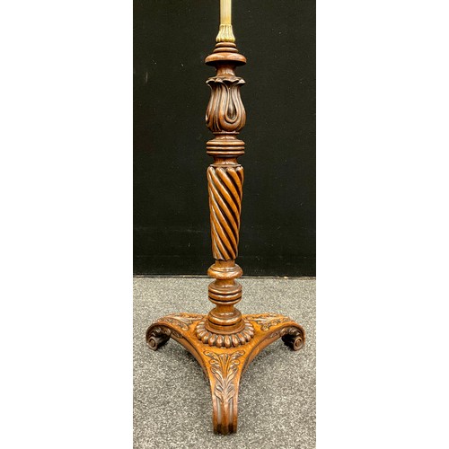 39 - A carved walnut and brass standard lamp, the shade supported by a reeded brass pole, upon a lower co... 