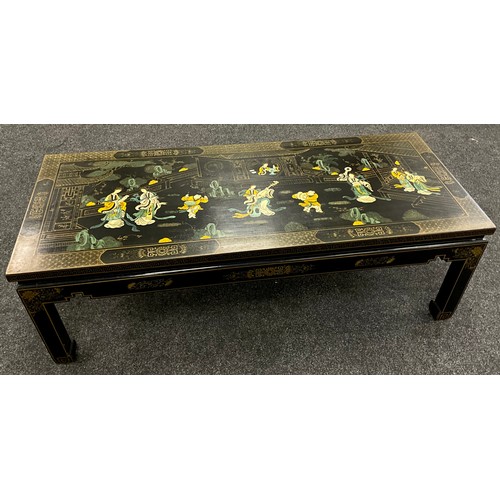 79 - A Chinoiserie black lacquer-work effect coffee table, painted to the top with musicians and ladies w... 