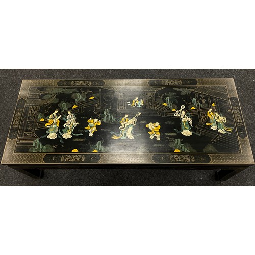 79 - A Chinoiserie black lacquer-work effect coffee table, painted to the top with musicians and ladies w... 