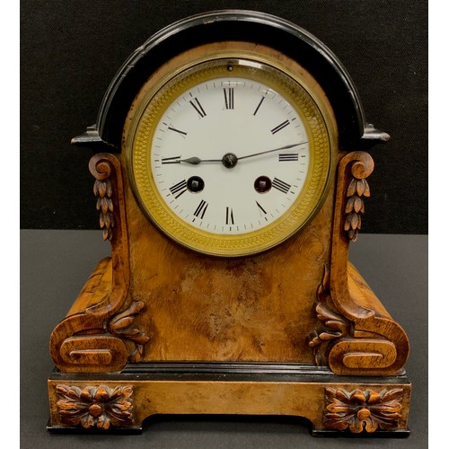 84 - A carved walnut and ebonised wood mantel clock, twin winding holes, eight day movement, Roman numera... 